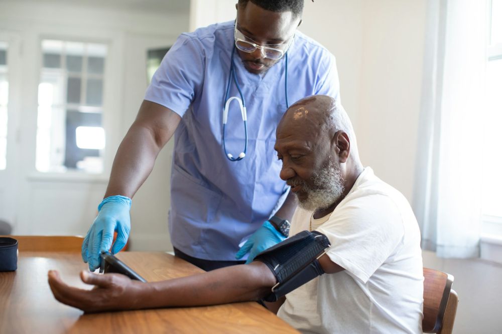 Home nurse checking an elderly man’s blood pressure